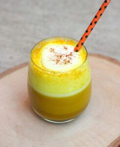 vaso de cristal con zumo amarillo y pajita naranja