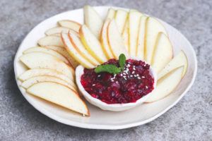 manzana cortada con salsa de frambuesas