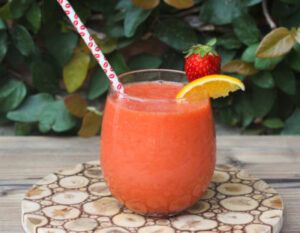 batido de fresa y naranja en un vaso de cristal y pajita