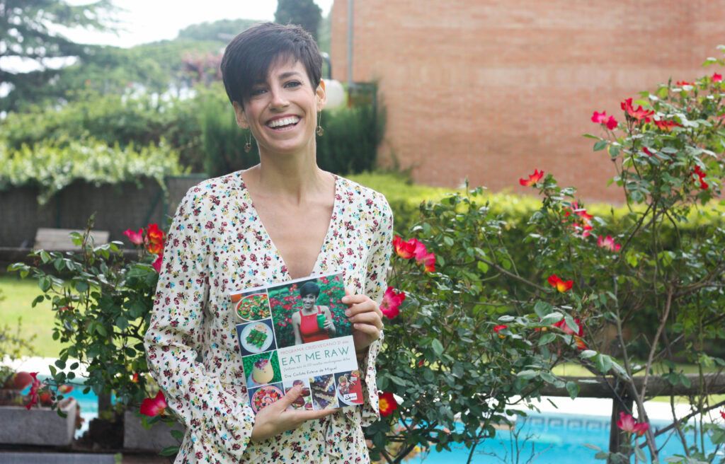 mujer sonriendo y sosteniendo el libro de recetas Programa Crudivegano 21 días Eat Me Raw
