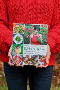 mujer sosteniendo el libro de recetas Programa Crudivegano 21 días Eat Me Raw de la Dra. Carlota Esteve de Miguel