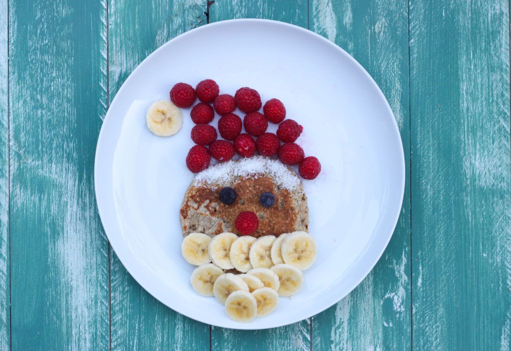 pancake con cara de papá noel, el gorro es de frambuesas y la barba de plátano