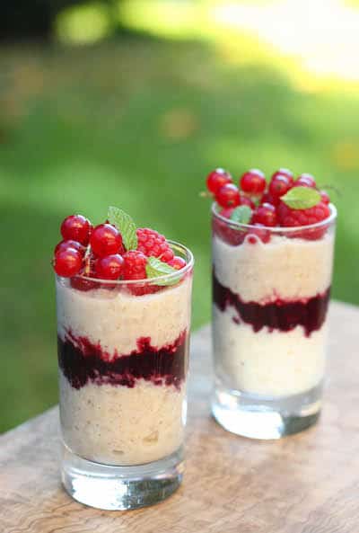 avena en un vaso con salsa de frutos rojos y grosellas por encima