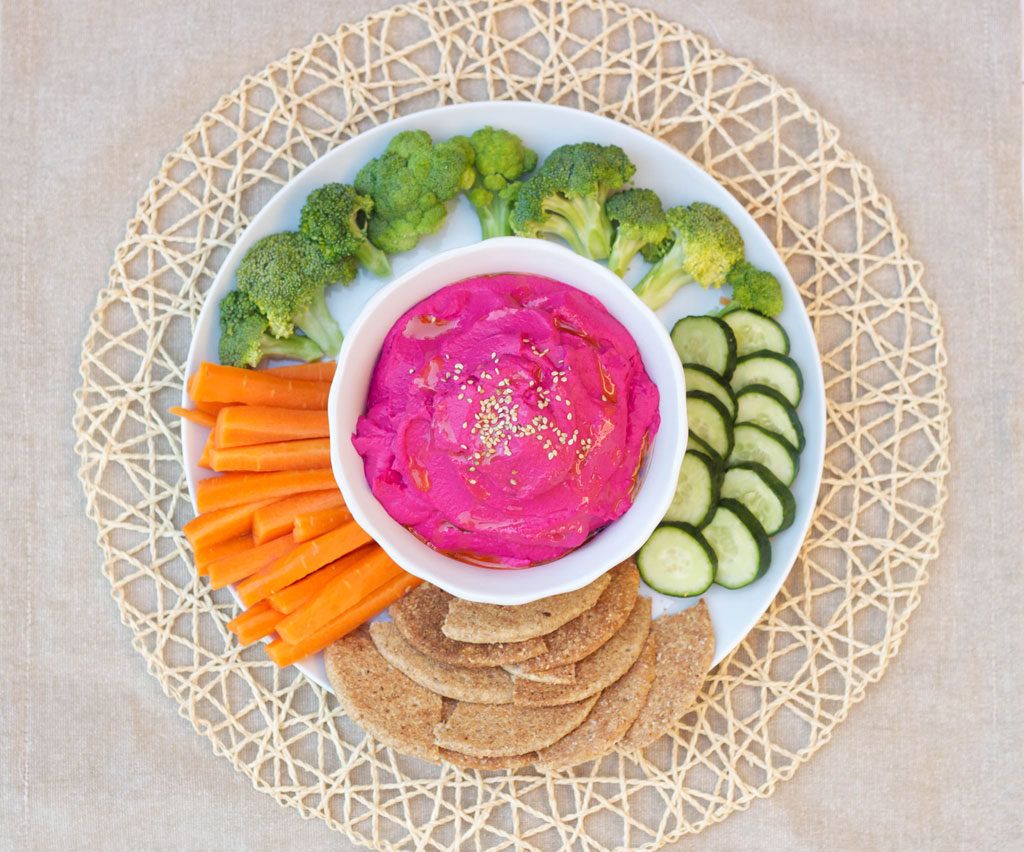 dip rosa en un bol servido con verduras y pan