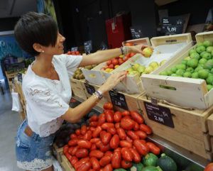 mujer comprando frutas y verduras en el colmado