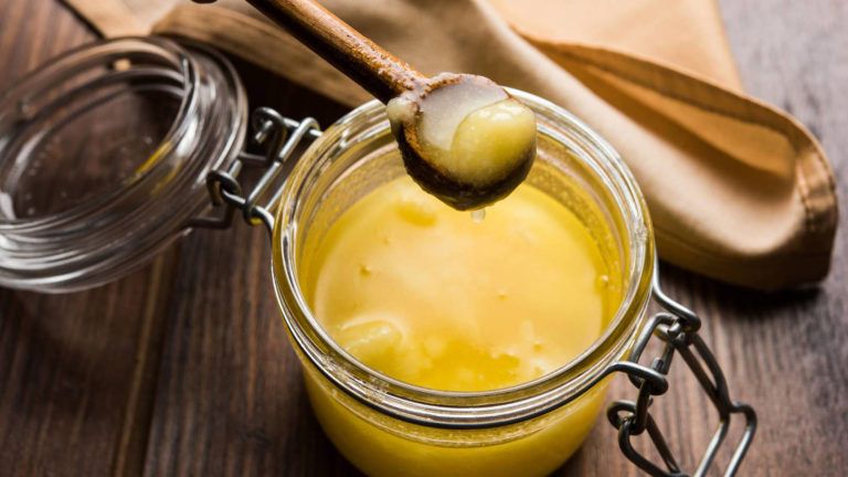 GHEE en un bote de cristal servido con cuchara de madera